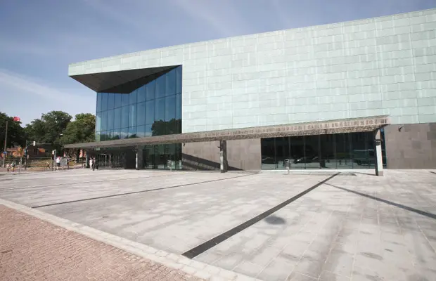 Moderne Architektur eines Gebäudes mit großen Glasfenstern und einer verglasten Fassade. Schlichte, rechteckige Form.