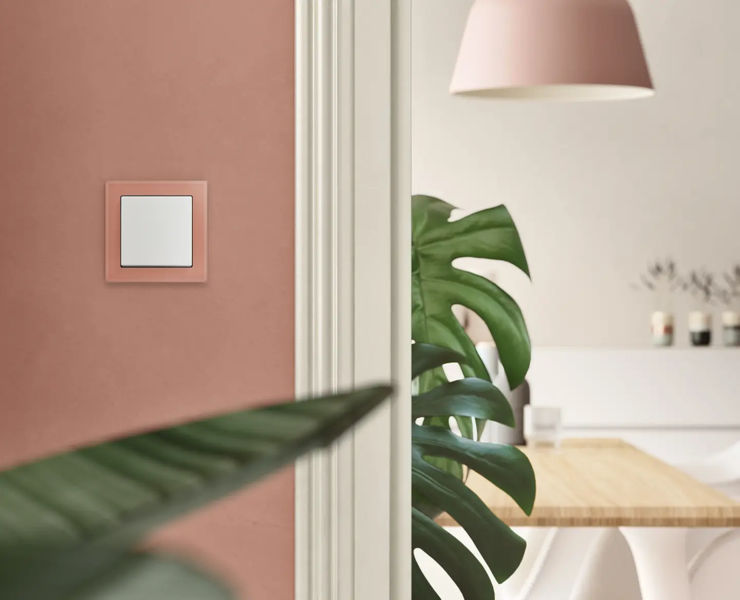 Wandschalter in einem modernen Raum mit einer Pflanze im Vordergrund und einem Esstisch im Hintergrund.